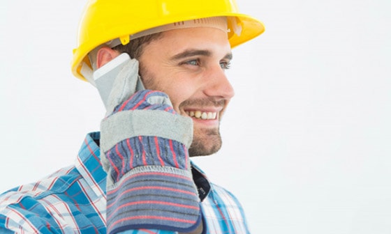 A foreman talks to a customer on his phone