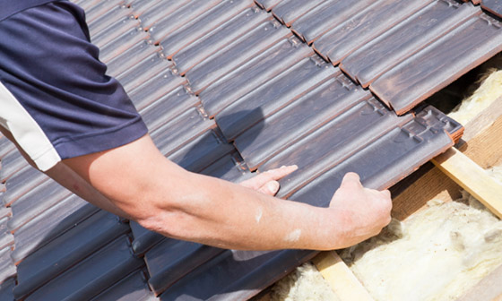 A roofer installs steel roofing.